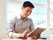 istock Asian man, tablet and marketing manager doing online planning in a modern office while reading email communication. Happy startup businessman with smile, technology and social media project at work 1448486514
