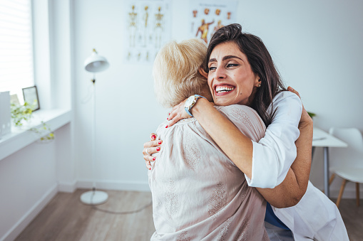 Shot of a young nurse caring for a senior woman. Portrait of optimistic old lady with caring young woman doctor, smiling happy senior mature grandmother with nurse or caregiver in hospital or at home, elderly healthcare concept
