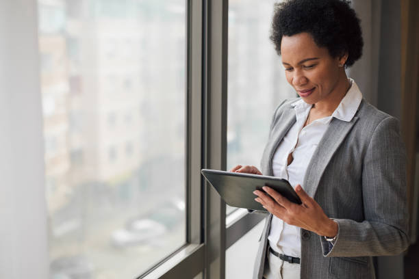 istock Grinning african american woman, checking her tablet, reading her mail. 1448488612