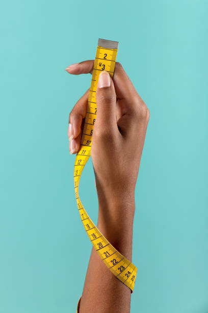 istock Black female hand showing tape measure 1448489118