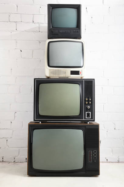 白いレンガの背景に4台の古いテレビが立っています。 - box white blank computer software ストックフォトと画像