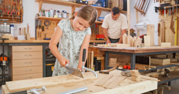 istock Girl cutting wooden plank 1448491852