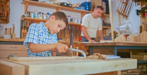istock Boy cutting wooden plank 1448491879