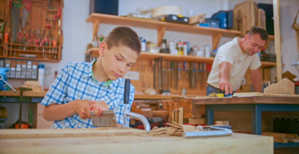 istock Boy cutting wooden plank 1448491883