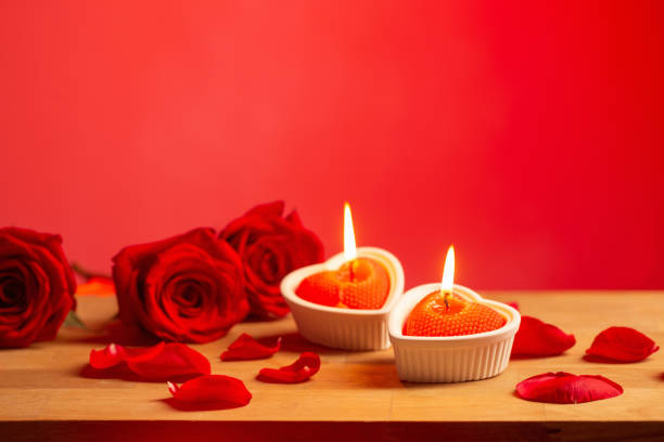 istock red roses with burning candles on red background 1448498961