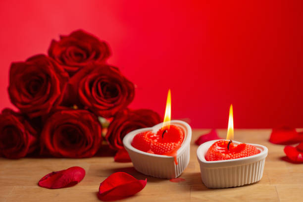 istock red roses with burning candles on red background 1448498966