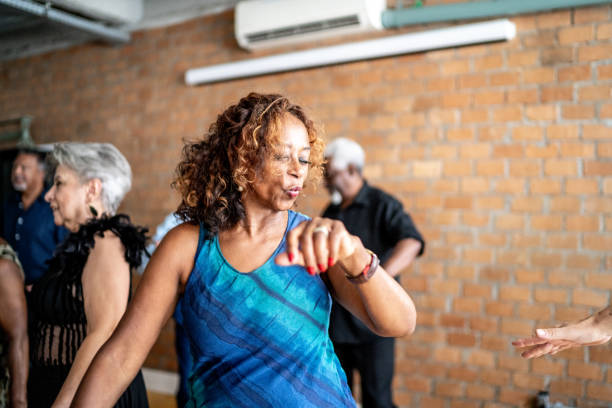 une femme âgée dansant avec ses amis dans une salle de danse - fitness dance photos et images de collection