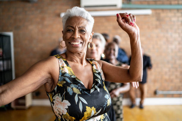 portrait of a senior woman dancing with her friends on a dance hall - åldrande bildbanksfoton och bilder