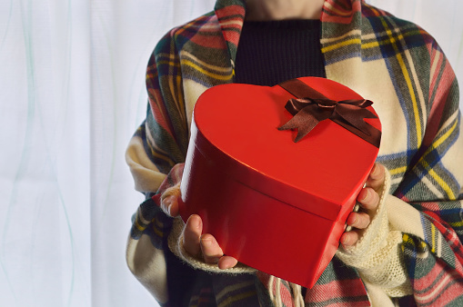 women holding a heart-shaped gift box/studio shot