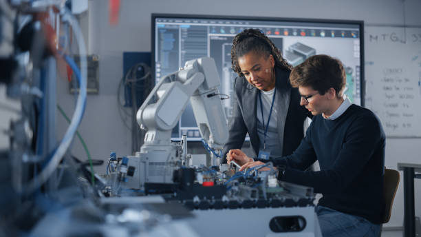 Male Student Engineer Discussing Ideas with Black Teacher while Working with Computer Processor. Man Uses Screwdriver. High-Tech Science and Engineering Concept. Medium Shot Male Student Engineer Discussing Ideas with Black Teacher while Working with Computer Processor. Man Uses Screwdriver. High-Tech Science and Engineering Concept. Medium Shot science and technology stock pictures, royalty-free photos & images