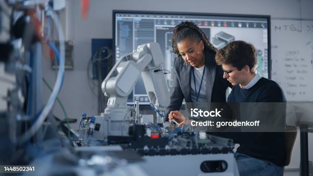 Male Student Engineer Discussing Ideas With Black Teacher While Working With Computer Processor Man Uses Screwdriver Hightech Science And Engineering Concept Medium Shot Stock Photo - Download Image Now