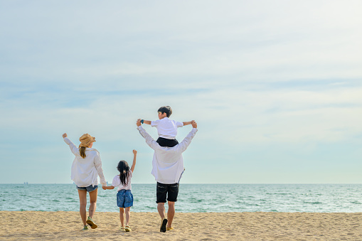 Family with beach therapy, Happy family spending time together at beach, Father give son piggyback on the beach, Travel on beach with blue sky view, Family with holiday and travel concept