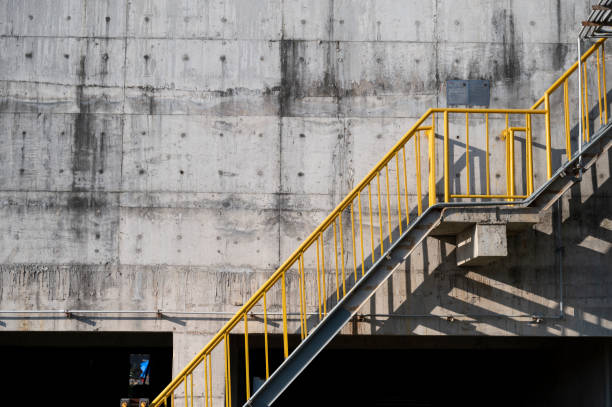 металлические лестничные желтые перила на бетонной стене - concrete wall railing metal bannister стоковые фото и изображения