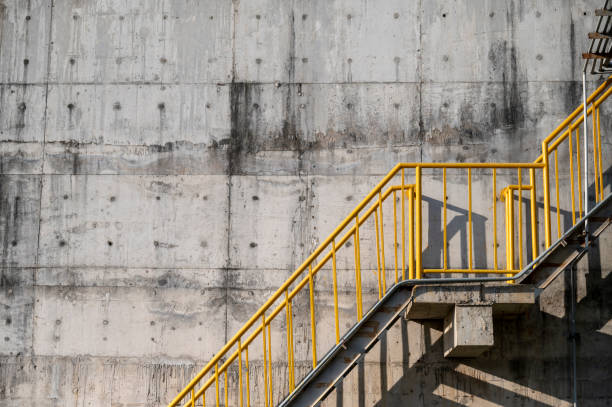 металлические лестничные желтые перила на бетонной стене - concrete wall railing metal bannister стоковые фото и изображения
