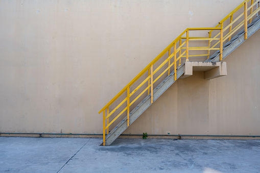 Industrial metal staircase with yellow railings in a chemical factory