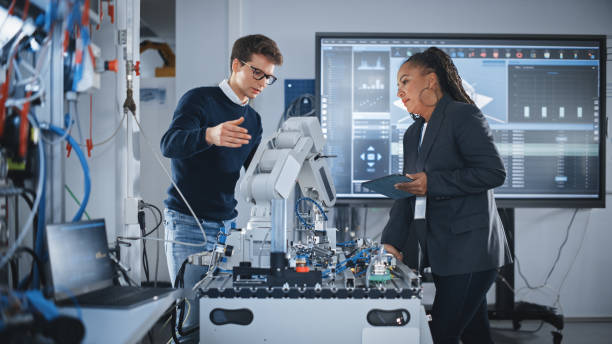 istock Futuristic Design of AI Robot Hand. Black Engineer Telling About Innovative Robot Arm to Students or Start-uppers. Advanced Robotics Technology for Factory Working Concept. Slow Motion. 1448503753