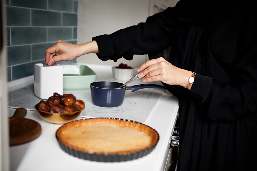 Woman Preparing pie on stove. Hands close up