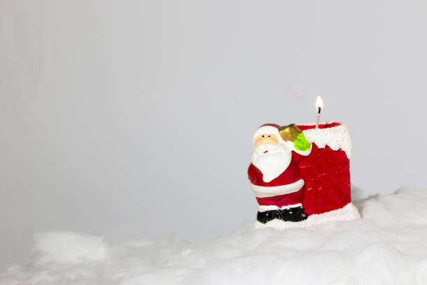 istock Santa's candle in the snow, creative holiday design, minimal concept 1448504753