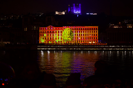 Fantastic image representing a lion projected on a building on the quay of saone with the basilica Notre Dame de Fourviere in the background for the Festival of lights 2022.