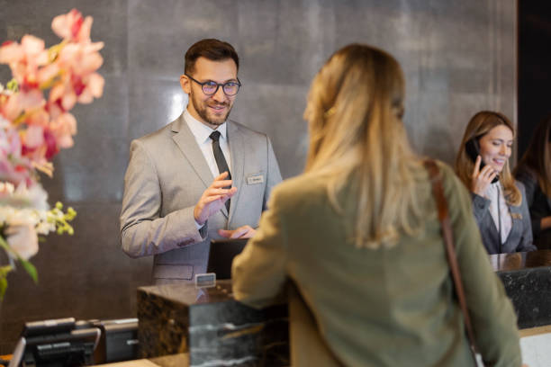istock Male receptionist at front office talking with female guest 1448506102