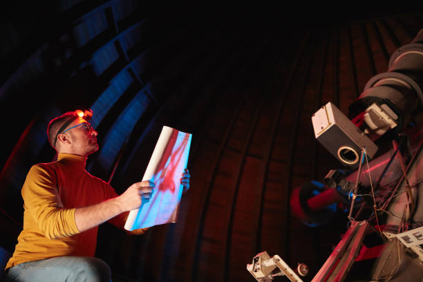 istock Astronomer with a big astronomical telescope in observatory doing science research of space and celestial objects. 1448506213