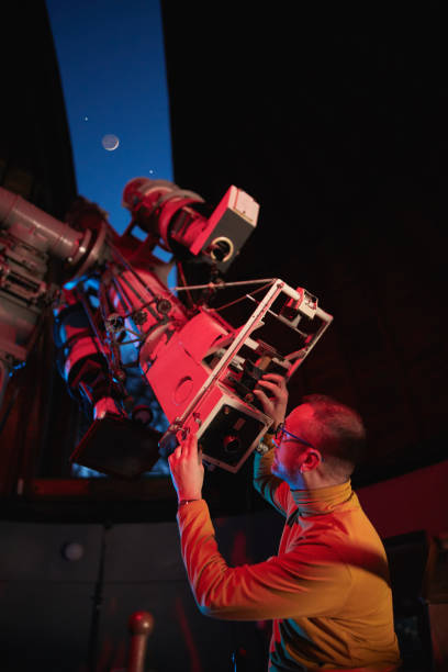 istock Astronomer with a big astronomical telescope in observatory doing science research of space and celestial objects. 1448506242