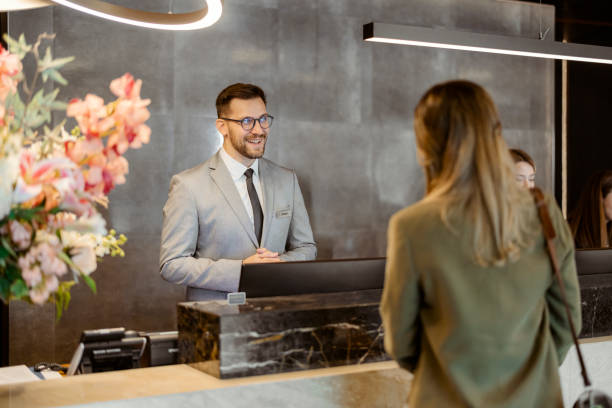 istock Male receptionist at front office talking with female guest 1448506301