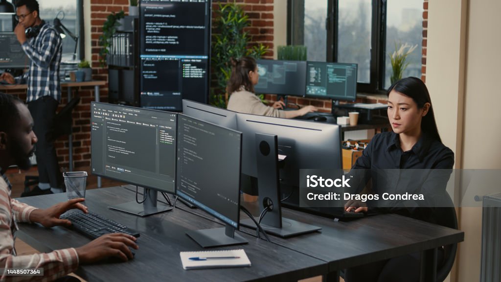 Two Focused Coders Facing Each Other Writing Code In Software ...
