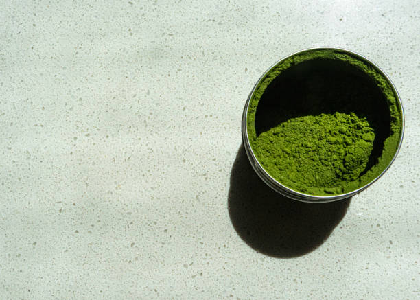 istock Matcha green tea powder in a tin on a white background 1448508133