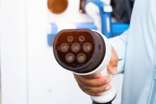 istock Hand holding Charge EV battery point for electric connector engine Plug Charging station vehicle supply equipment supplies electrical power charger, Clean energy future transport environment friendly 1448509669