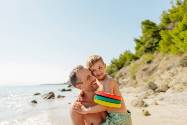 Photo of father and son having precious moments together while enjoying a summer day at the beach.