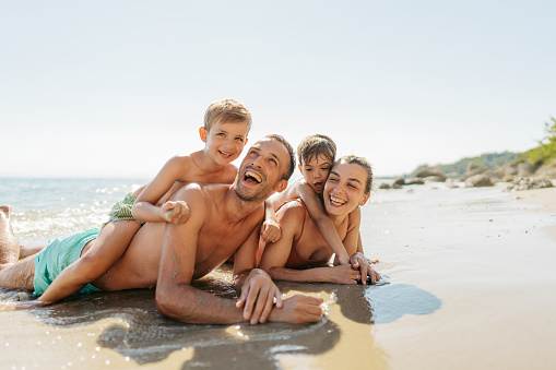 Portrait of a happy family enjoying together at the wild beach