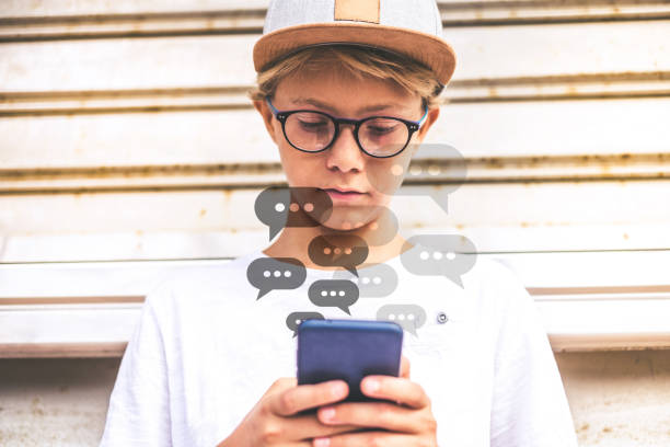 istock Beautiful trendy boy using smartphone in an exotic context. Image of kid playing with mobile phone. Caucasian blonde young man communicate with friends. Youth, new trend technology, online concept. 1448512484