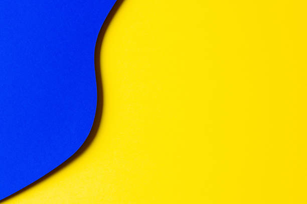 istock Abstract colored paper texture background. Minimal paper cut style composition with layers of geometric shapes and lines in yellow and blue colors. Top view 1448515492