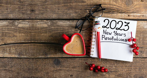 istock New year resolutions 2023 on desk. 2023 resolutions list with notebook, coffee cup, decorations on table. Goals, resolutions, plan, action concept. New Year 2023 background 1448518943