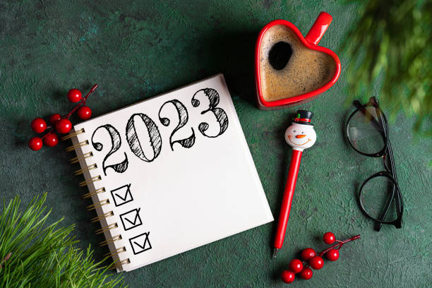 istock New year resolutions 2023 on desk. 2023 resolutions list with notebook, coffee cup, decorations on table. Goals, resolutions, plan, action concept. New Year 2023 background 1448519013