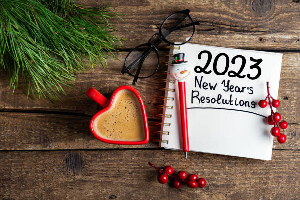 istock New year resolutions 2023 on desk. 2023 resolutions list with notebook, coffee cup, decorations on table. Goals, resolutions, plan, action concept. New Year 2023 background 1448519019