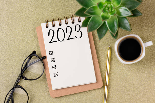 istock New year resolutions 2023 on desk. 2023 resolutions list with notebook, coffee cup on golden background. Goals, resolutions, plan, action, checklist concept. New Year 2023 template 1448519126