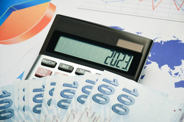 New year business and finance concept. Turkish money on a calculator with 2023 on the display and business finance graphs, documents on the desk stock photo