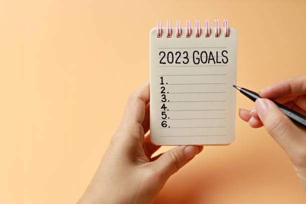 istock Businesswomen writing 2023 goals on notebook for new year resolution plan. 1448523007