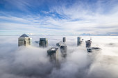 The modern skyline of Canary Wharf, London, during a foggy day