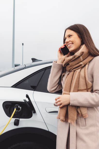 istock A woman talks on the phone while charging her electric car 1448527909