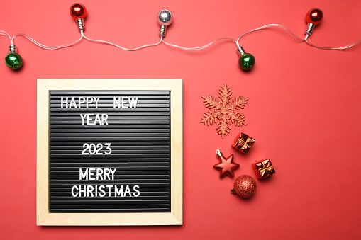 New year concepts. Happy new year, 2023 and Merry Christmas text on the letter board with Christmas decoration on the red background