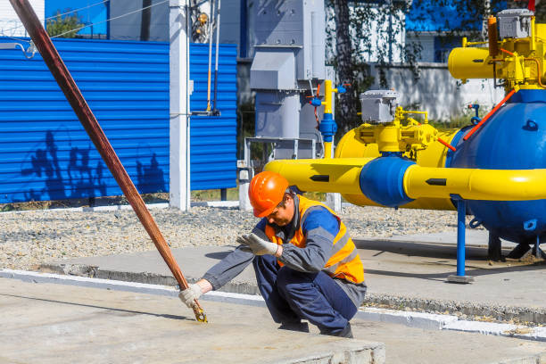 istock Slinger lays concrete slab on construction site on summer day. Worker in protective vest and construction helmet supervises laying of base on construction site. 1448529406