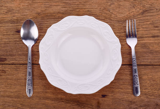 istock plate and spoon fork on wooden floor 1448529421