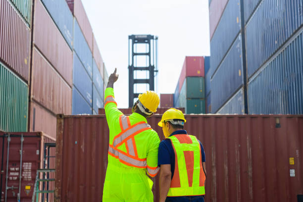 istock Industrial worker and logistic worker in safety helmet checking and managing containers in cargo freight ship for import and export 1448531444