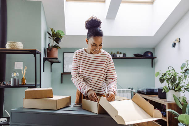 Young woman unpacks several online packages that have just arrived stock photo