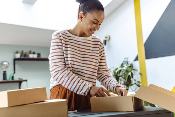istock Young woman unpacks several online packages that have just arrived 1448533948