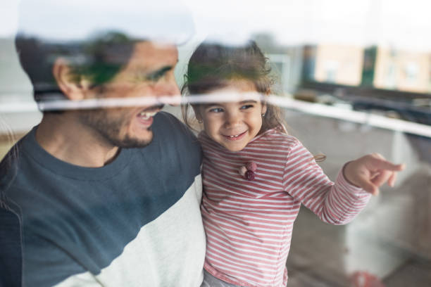 Single father playing with daughter while working on home renovation process.