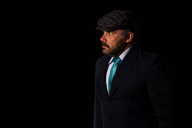 istock Businessman looking aside wearing a suit and a flat cap 1448537352